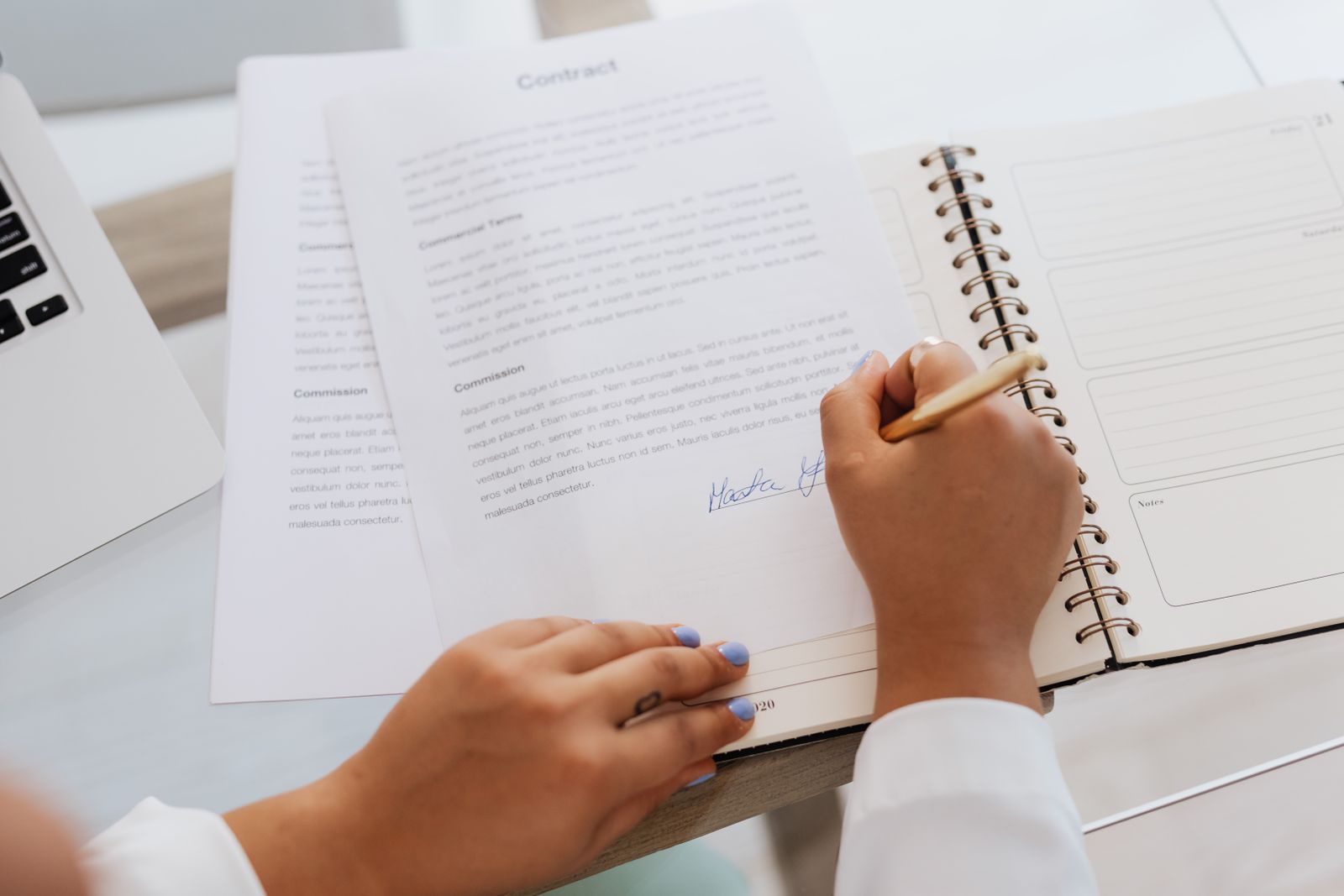 A person signing a printed contract by hand