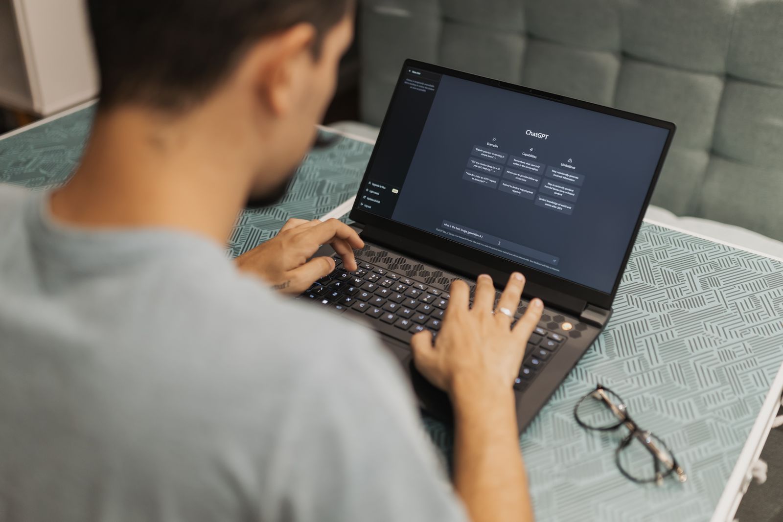 A person typing on a laptop with a ChatGPT conversation open on screen