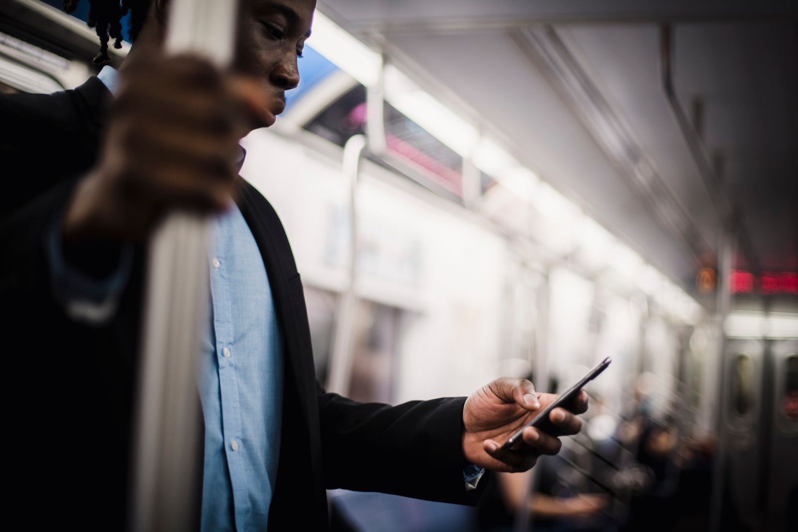 A person checking a phone app while commuting on a train