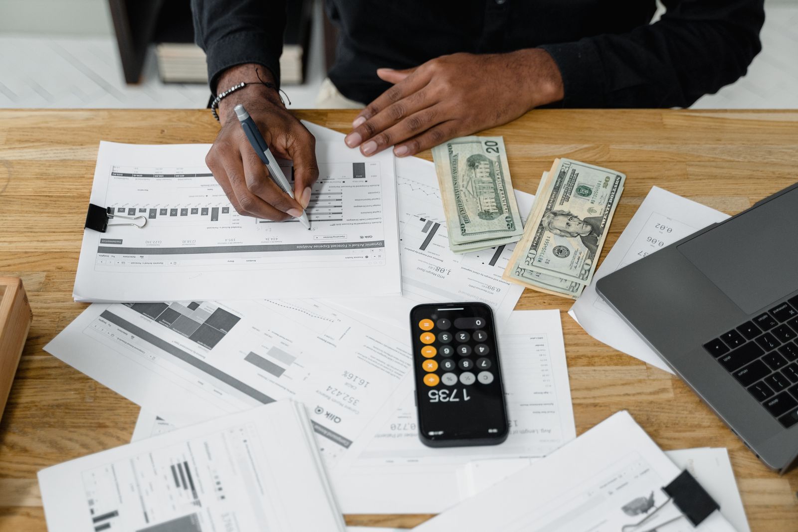 A professional reviewing financial documents and a calculator at a desk